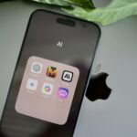 an iphone sitting on top of a table next to a leaf