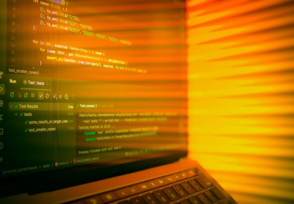 Laptop screen displaying code with orange glow.