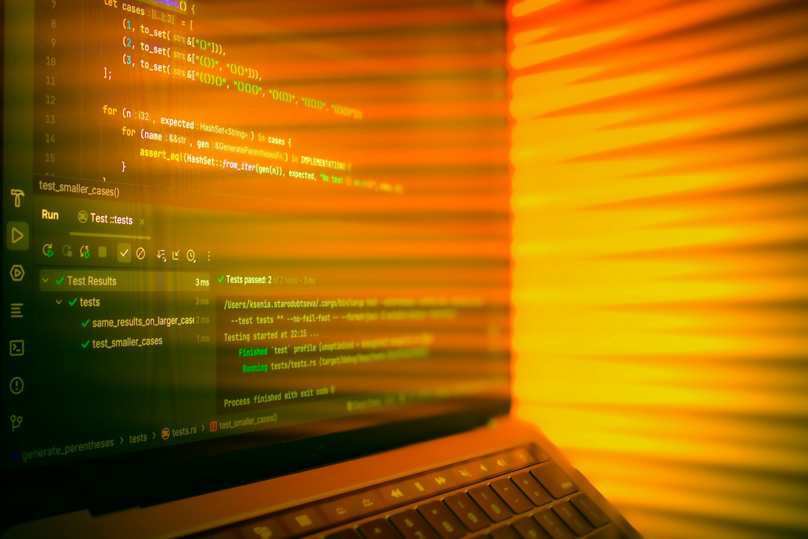 Laptop screen displaying code with orange glow.