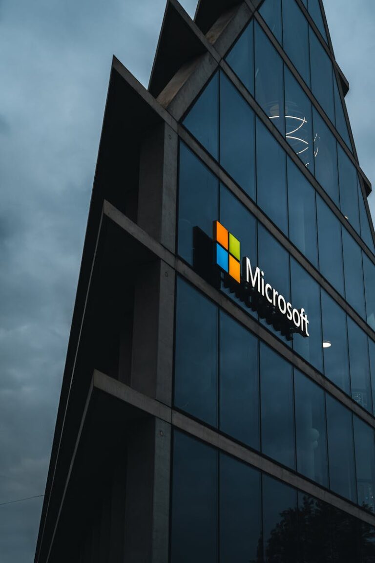 A modern Microsoft office skyscraper with glass facade against a cloudy evening sky.