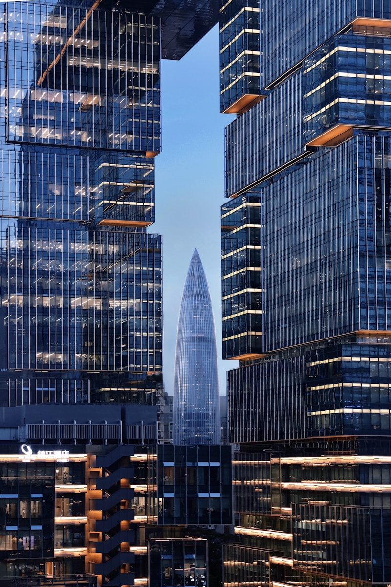 Modern architecture surrounds a tall, slender skyscraper.